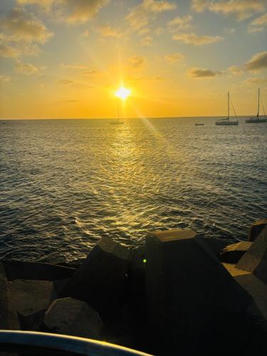 a sunset over the ocean with boats in the water at Stay, laugh, repeat! in Prainha