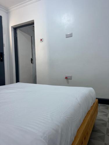 a bedroom with a large white bed in a room at Dallas auberge in Migori
