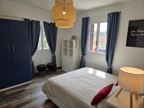 - une chambre avec un lit et des rideaux bleus dans l'établissement T2 rez de jardin de villa au calme, à Nice