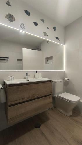 a bathroom with a sink and a toilet and a mirror at Apartamento ValentinaBeach in Torrox Costa