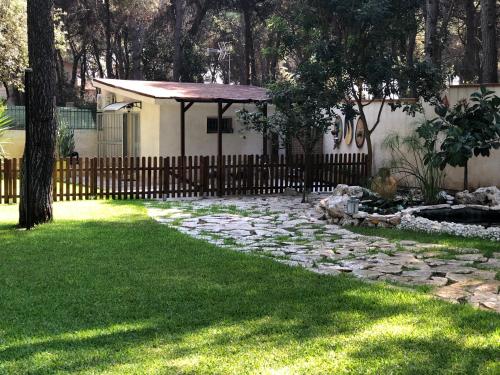a garden with a fence and a stone path at Bungalow Fatamorgana in Pulsano