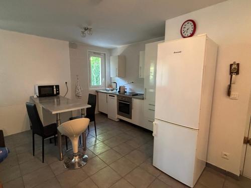 Una cocina con una mesa y un refrigerador blanco. en Appartement au bord de mer, en La Ciotat