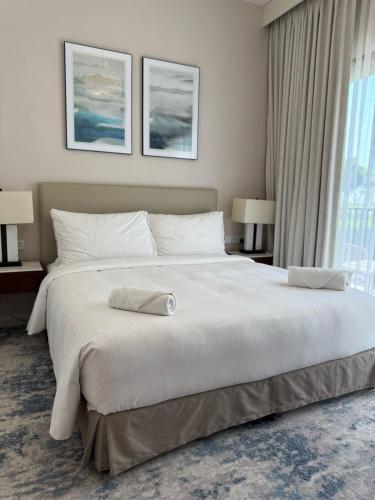 a large white bed in a room with a window at Address Beach Resort Fujairah Apartment Three Bedrooms by Blue World- 2 in Fujairah
