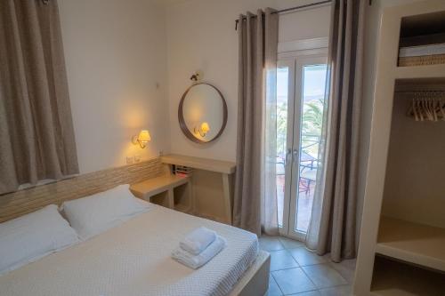 a bedroom with a bed with a mirror and a window at Villa Ostria in Koufonisia