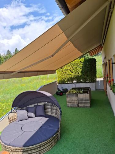 a canopy bed in a backyard with green grass at Apartment Panorama Val di Non in San Felice