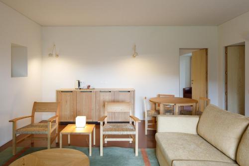 a living room with a couch and a table and chairs at Quinta do Outeiro 1598 in Ponte da Barca