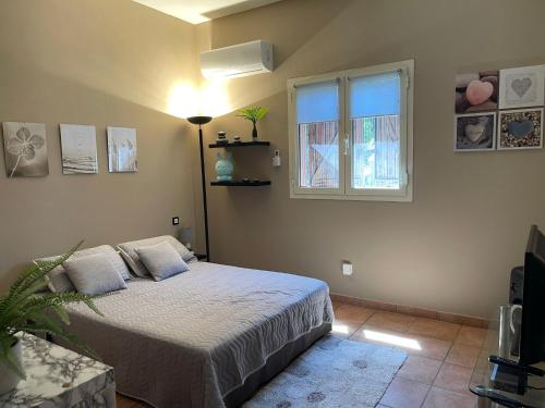 une chambre avec un lit et une fenêtre dans l'établissement Perle du Maquis, à Porto-Vecchio