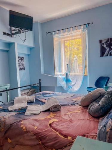 a bed in a blue room with a bedspread on it at La Locanda Del Brolio in Cantiano