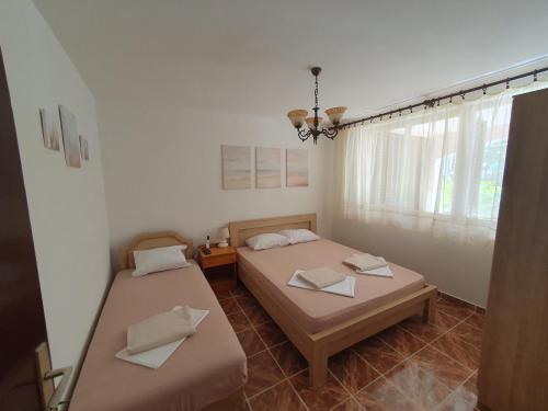two beds in a room with a window at Kiwi in Ulcinj