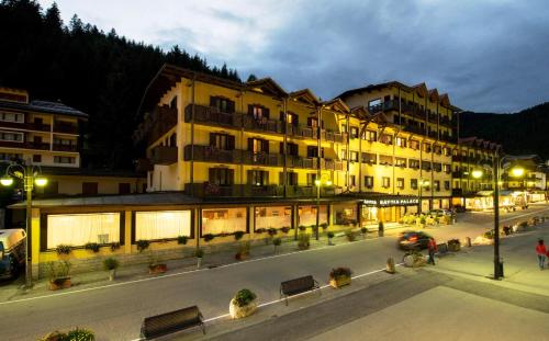 a large building with benches in front of it at Savoia Palace Hotel in Madonna di Campiglio