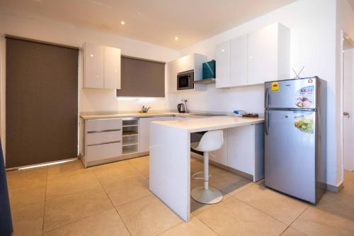 a kitchen with white cabinets and a refrigerator at Tills Beach Resort in Fetta
