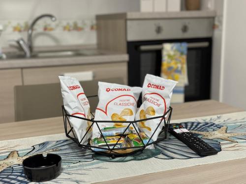 a basket of food and a remote control on a counter at Nido di mare in San Benedetto del Tronto
