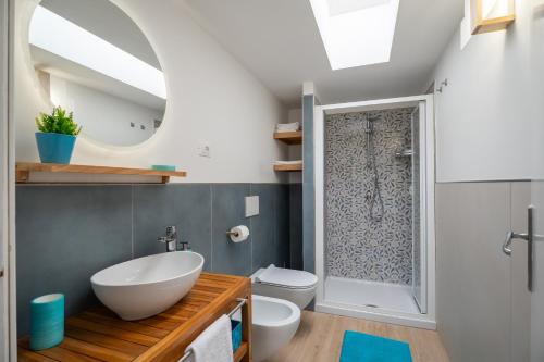 une salle de bain avec un lavabo, des toilettes et un miroir dans l'établissement 2 Terraces and Pergola House in Ischia, à Ischia