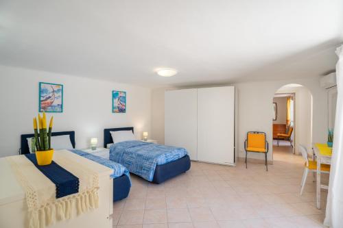 une chambre avec deux lits et une table et des chaises dans l'établissement 2 Terraces and Pergola House in Ischia, à Ischia