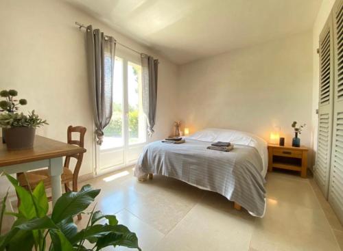 une chambre avec un lit, une table et une fenêtre dans l'établissement Chez Marie-Hélène et Pascal, au Plan-de-la-Tour