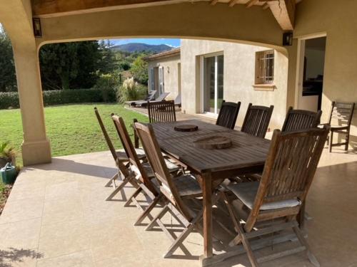 une table et des chaises en bois sur une terrasse dans l'établissement Chez Marie-Hélène et Pascal, au Plan-de-la-Tour