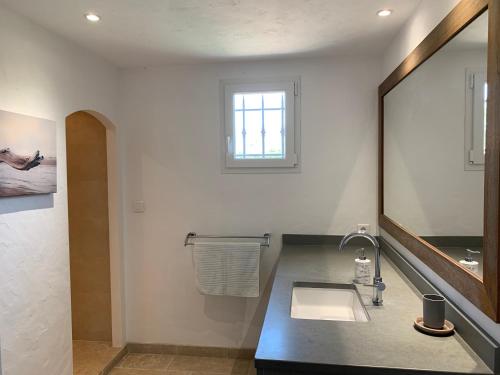 une salle de bain avec un lavabo et un grand miroir dans l'établissement Chez Marie-Hélène et Pascal, au Plan-de-la-Tour