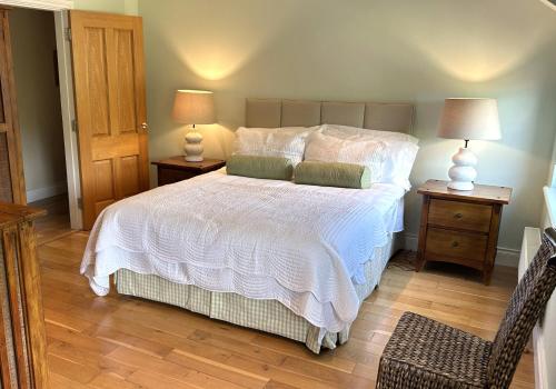 a bedroom with a white bed with two night stands at 3 bedroom townhouse in the heart of Kenmare in Kenmare