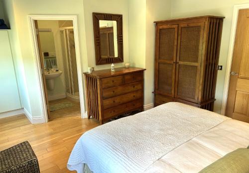 a bedroom with a bed and a dresser and a mirror at 3 bedroom townhouse in the heart of Kenmare in Kenmare