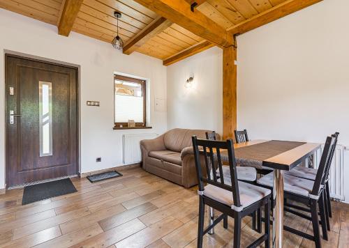 a dining room with a table and a couch at Dulówka in Smerek