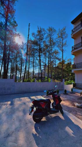 a motorcycle parked in a parking lot next to a building at XTSY Family Rooms & Dorms in Shillong