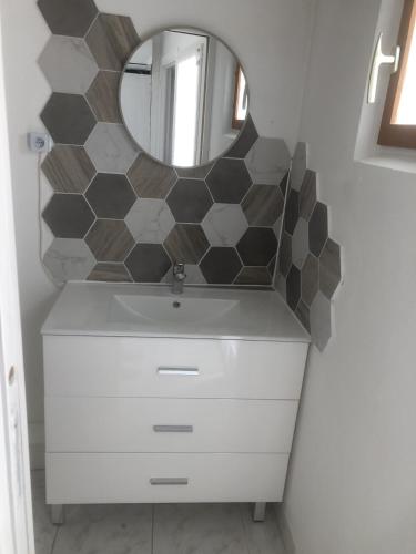 une salle de bain avec un lavabo blanc et un miroir dans l'établissement Appartement au calme 4 personnes, à Saint-Paulet-de-Caisson