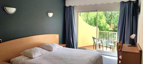 a bedroom with a bed and a balcony at Hôtel Sous l'Olivier in Buis-les-Baronnies