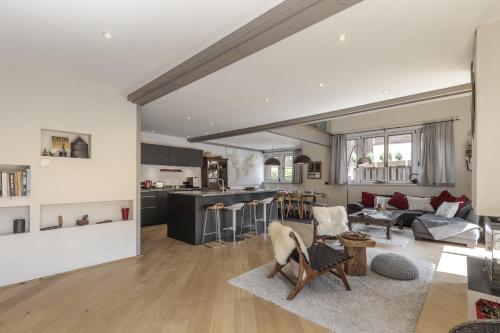un salon et une cuisine avec un canapé et une table dans l'établissement Chalet Zen - Sauna Hammam - Vue Mont-Blanc, à Chamonix-Mont-Blanc