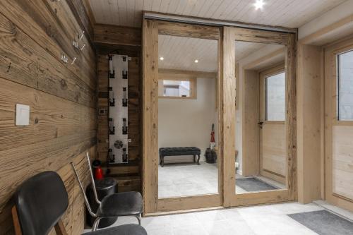 une pièce avec des murs en bois et une porte avec des chaises dans l'établissement Chalet Zen - Sauna Hammam - Vue Mont-Blanc, à Chamonix-Mont-Blanc