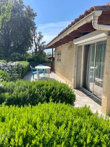 un patio avec une table et des chaises dans une cour dans l'établissement Maisonnette indépendante avec piscine, à Réauville
