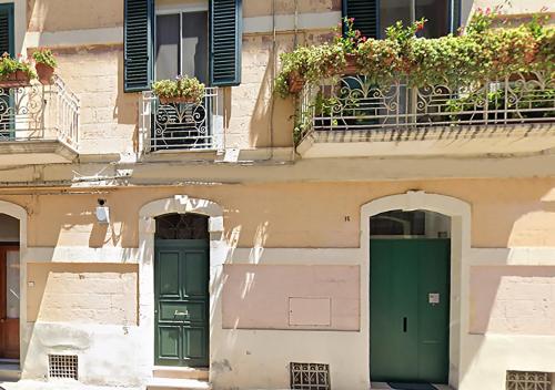 a building with two green doors and windows at 16Sassi in Matera