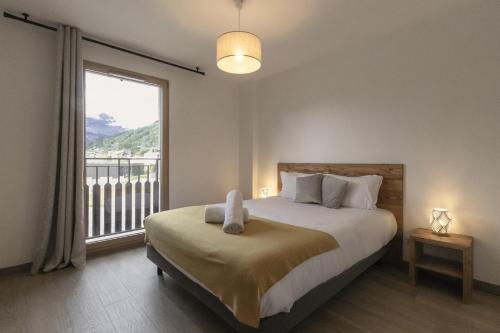 une chambre avec un lit et une grande fenêtre dans l'établissement Le 201 - Proche Centre Ville - Ski In - Ski Out, à Saint-Gervais-les-Bains