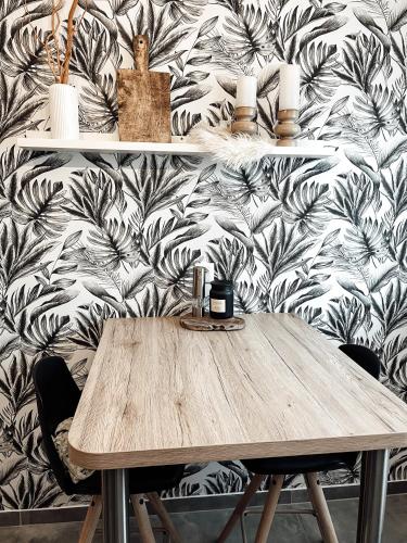 une table en bois devant un mur dans l'établissement Le cocon Blånc Metz - T2 - Parking privé - Balcon - Nouvelle Ville, Gare, à Metz