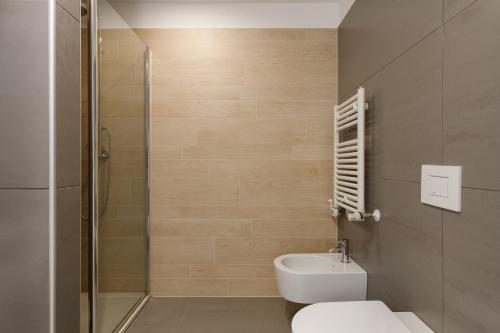 a bathroom with a toilet and a glass shower at Portopiccolo Apartments - Ulivo sul golfo in Portopiccolo Sistiana