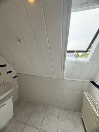 un bagno con soffitto con finestra e lavandino di Einzelzimmer mit Gemeinschaftsbad ohne Küche a Norimberga