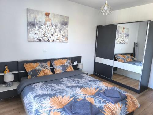 a bedroom with a large bed and a mirror at Апартамент Славяна in Velingrad