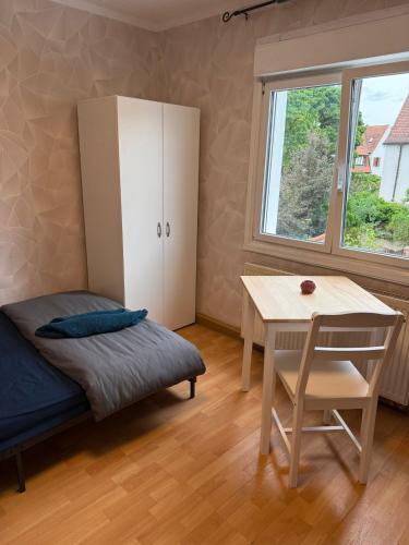 una camera da letto con un letto, un tavolo e una scrivania di Einzelzimmer mit Gemeinschaftsbad ohne Küche a Norimberga