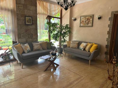 a living room with two couches and a table at Oleander House and Tennis Club in Sunny Beach