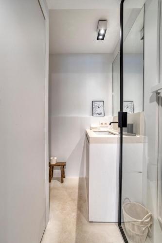a white bathroom with a sink and a mirror at StudioV in Knokke-Heist