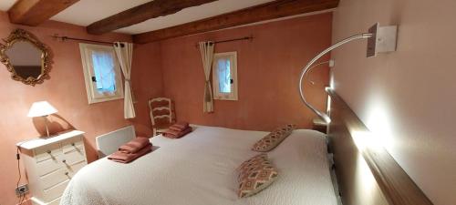 une chambre avec un lit blanc dans une pièce dans l'établissement Le Jas des Sagnières - Gite de Charme en Haute Provence -, à Sigoyer