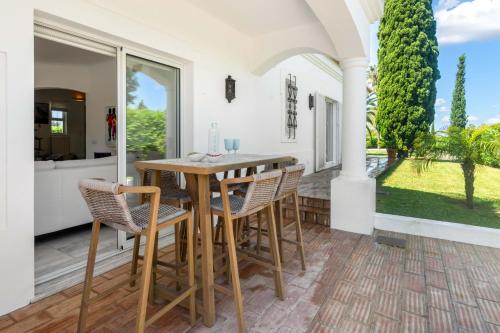 a dining room with a table and chairs on a patio at Casa Rosella in Carvoeiro