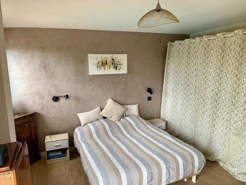 une chambre avec un lit avec une couverture rayée dans l'établissement Central Park Villa, à Roquefort-les-Pins