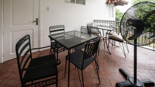 a table and chairs sitting on a patio at MiraNamin Nest CALACHUCHI Room in Unique Historic Home - Balcony, Rooftop, Garden View, Shared Kitchen, Pet Friendly with a Fee in Manila