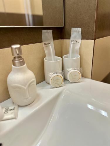 a bathroom sink with a bottle of soap and toothbrushes at Apartment Lučka II in Banjol