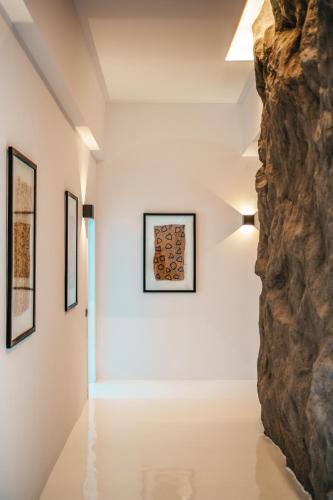 a room with a rock wall and paintings on the wall at Mega Mansions Mykonos in Elia