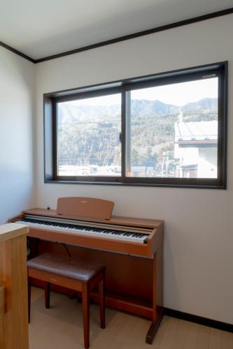 a piano in a room with a large window at 3LDK MAX12名 富士山が見える一棟貸 スタイリッシュデザイン Villa Sena in Nishikatsuracho