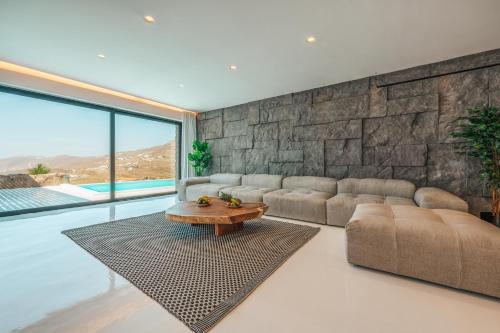 a living room with a couch and a table at Mega Mansions Mykonos in Elia