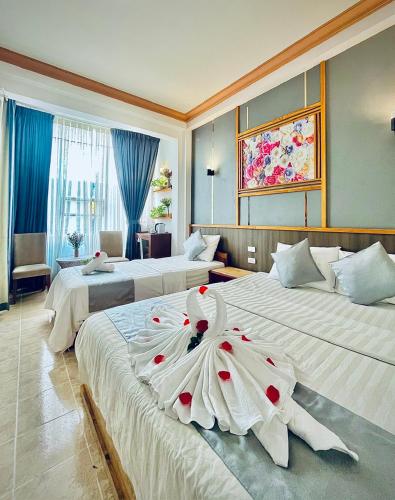 a hotel room with two beds with a flower on them at Na Nue Hotel in Ho Chi Minh City