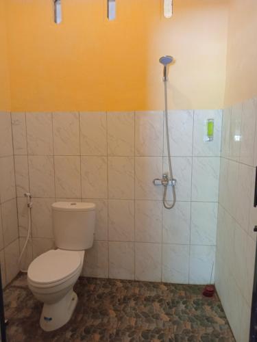 a bathroom with a toilet and a shower at Villa Aisyah sumbawa in Maluk