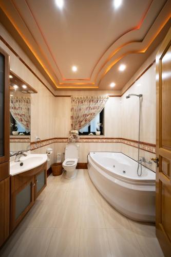 a bathroom with a tub and a toilet and a sink at Seafront living with private Garage in St. Paul's Bay